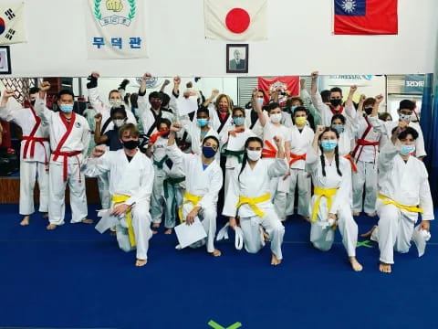 a group of people in white karate uniforms posing for a photo