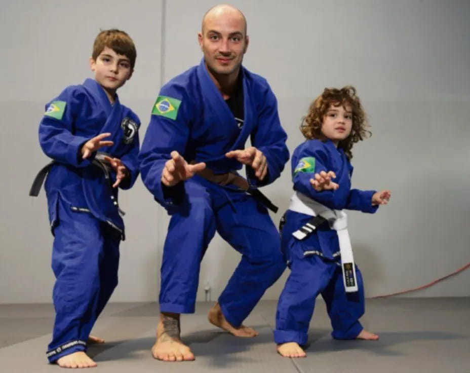 a person and two children in blue karate uniforms