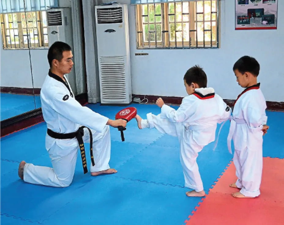 a person and two boys in karate uniforms