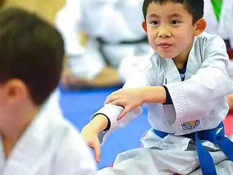 a young boy in a karate uniform
