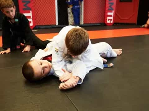 a boy lying on the floor with another boy standing behind him