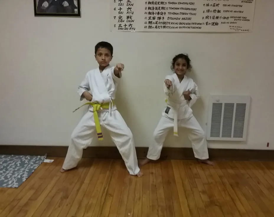 a couple of kids in karate uniforms