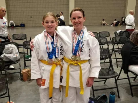 a couple of women wearing medals and posing for the camera