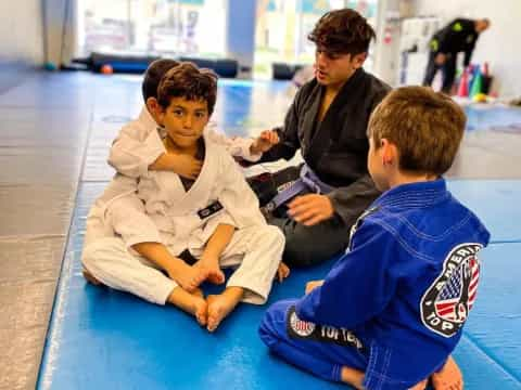 a group of people sitting on a blue mat