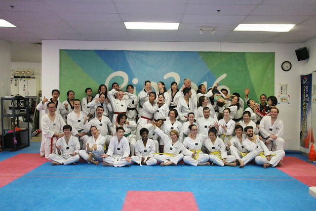 a group of people in white karate uniforms posing for a photo