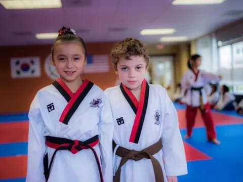 a couple of girls in karate uniforms