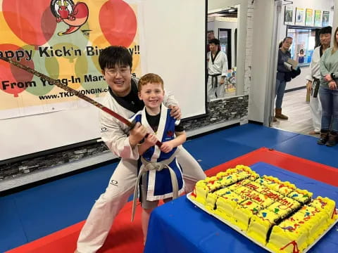 a person and a boy posing for a picture next to a cake