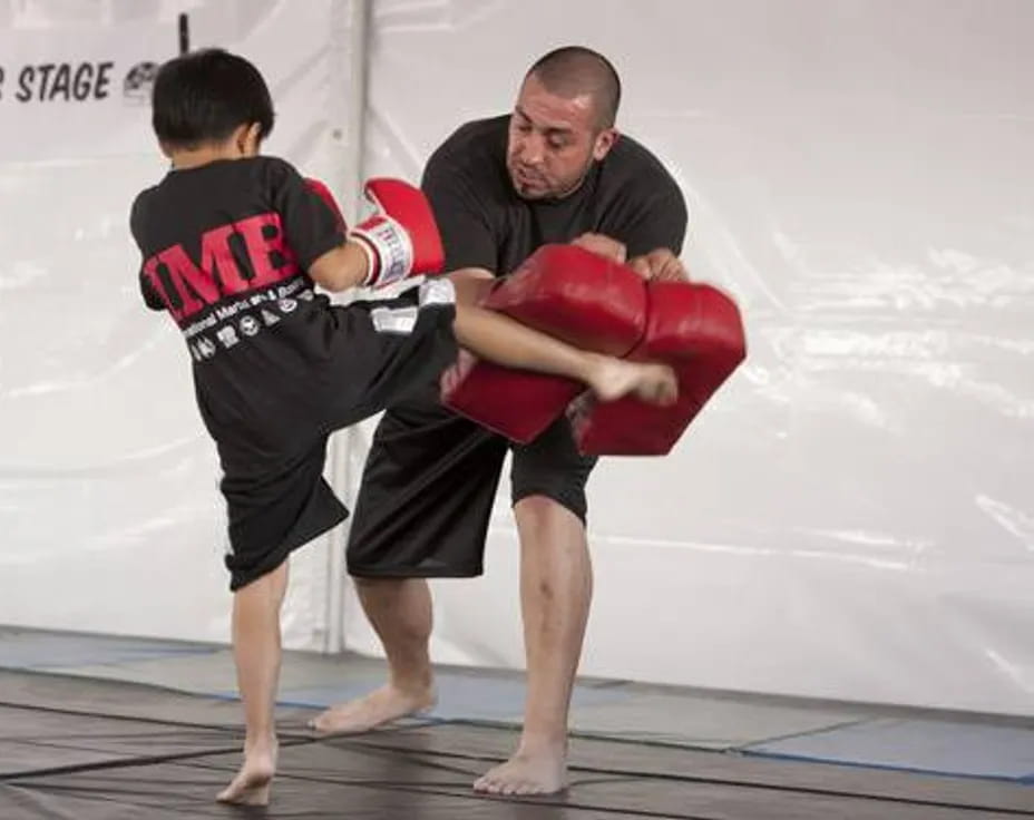 a man holding a boy in a boxing ring