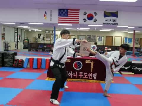 a person kicking another man in the face with a flag in the background