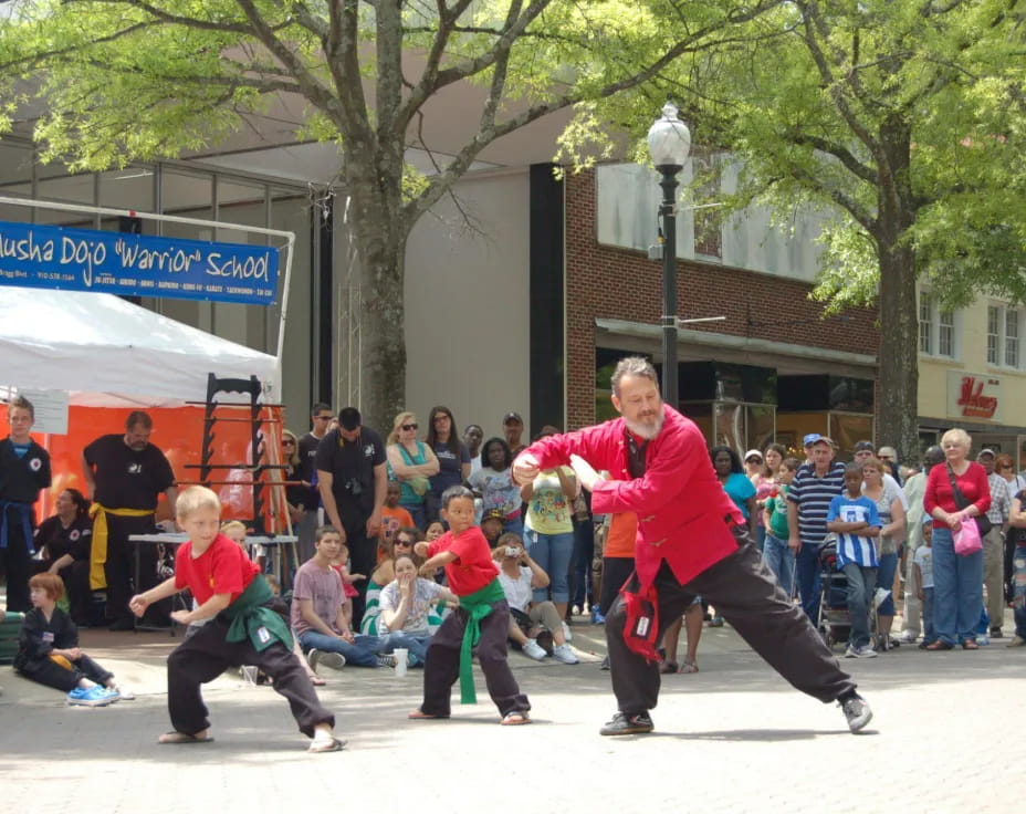 a person in red shirt and black pants running with a group of people watching