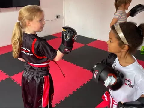 a couple of girls wearing boxing gloves