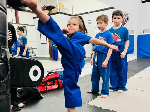 a group of children in blue karate uniforms