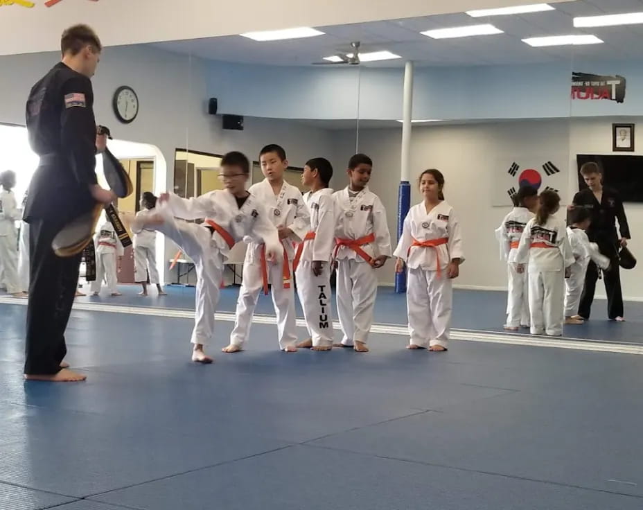 a person standing in front of a group of people in karate uniforms