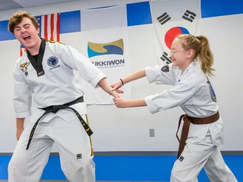 a man and a woman in karate uniforms shaking hands
