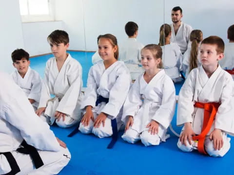 a group of people in white karate uniforms