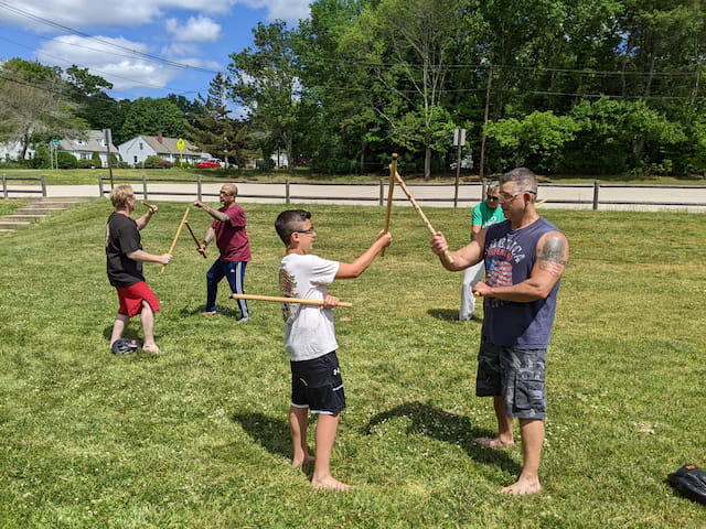 a group of people holding sticks