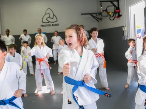 a group of children in white karate uniforms