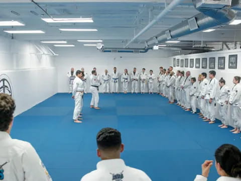 a group of people in white karate uniforms standing in a room