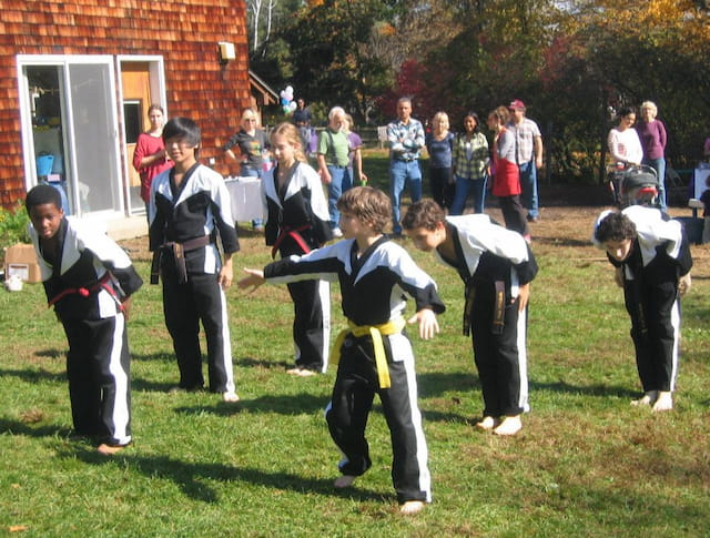 a group of children in black and white uniforms in a grassy area
