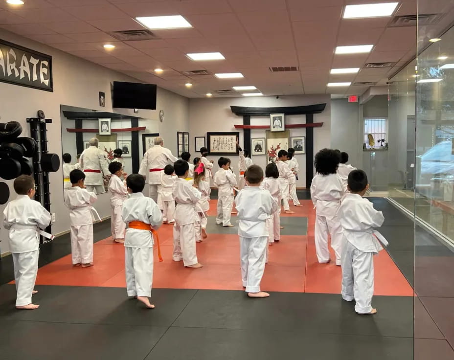 a group of people in white karate uniforms in a room