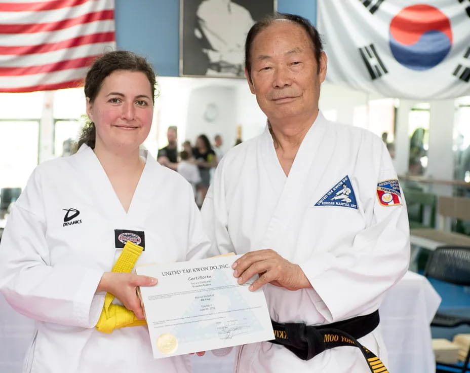 a man and a woman in white uniforms holding a certificate