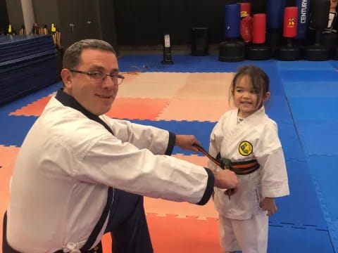a man and a girl in a karate uniform