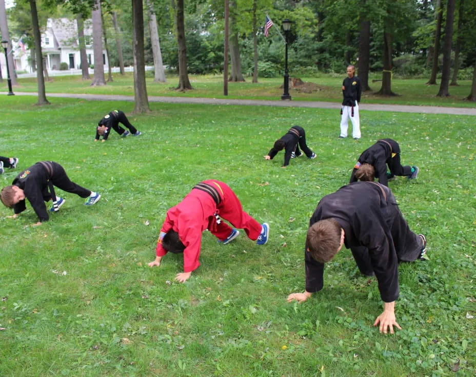 a group of people doing push ups in a park