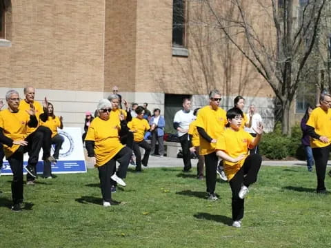 a group of people in yellow shirts running on grass