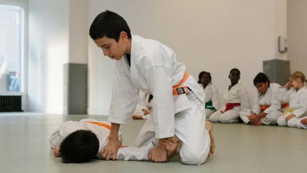 a man kneeling down to touch a boy's head