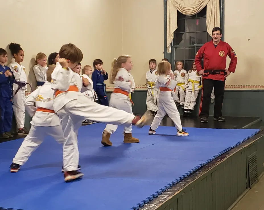 a group of children in karate uniforms