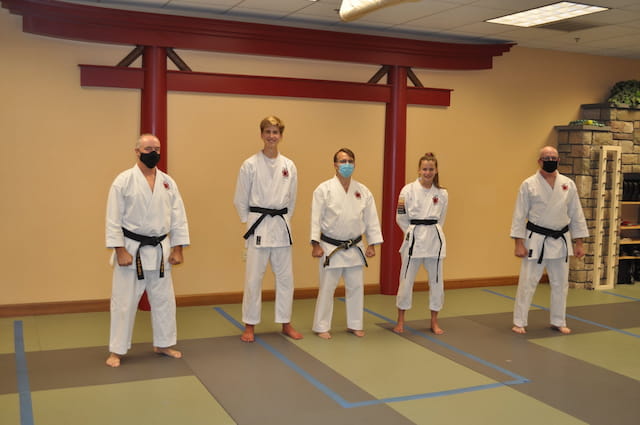 a group of people in white karate uniforms