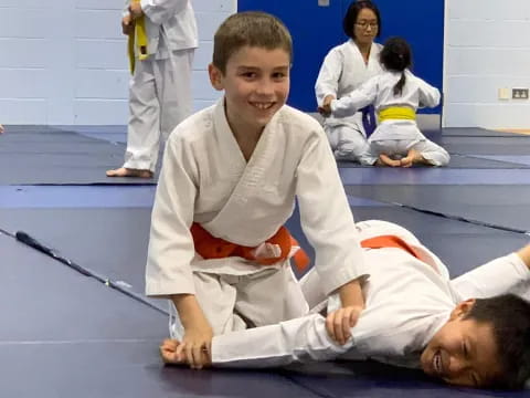 a boy lying on the floor with a person lying on the ground