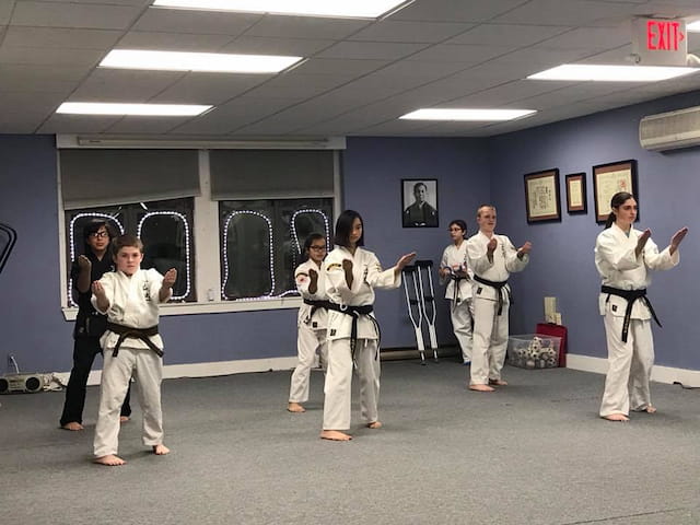 a group of people in white karate uniforms in a room