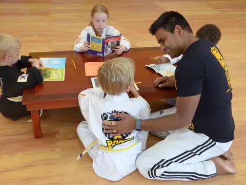 a person and a couple of kids sitting at a table