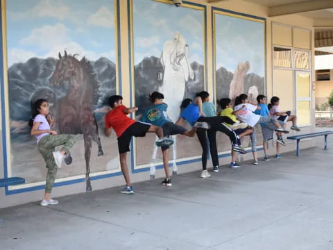 a group of people sitting on a bench in front of a large painting