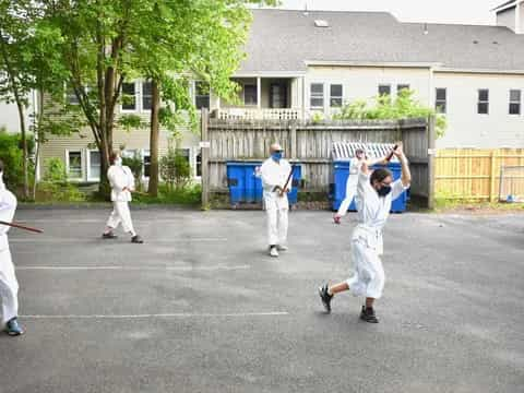 a group of people in white karate uniforms holding swords