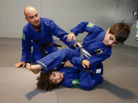 a person holding a boy in a karate uniform