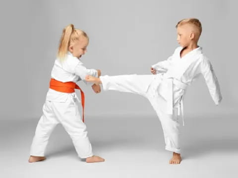 a couple of children in karate uniforms