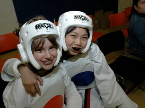 a couple of girls wearing white helmets