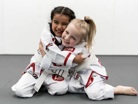 a person hugging a girl in a karate uniform