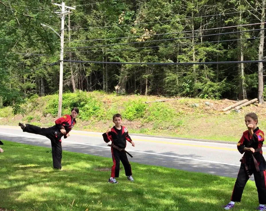 a group of people running on a road with trees in the background