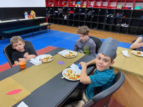 a group of boys eating at a table