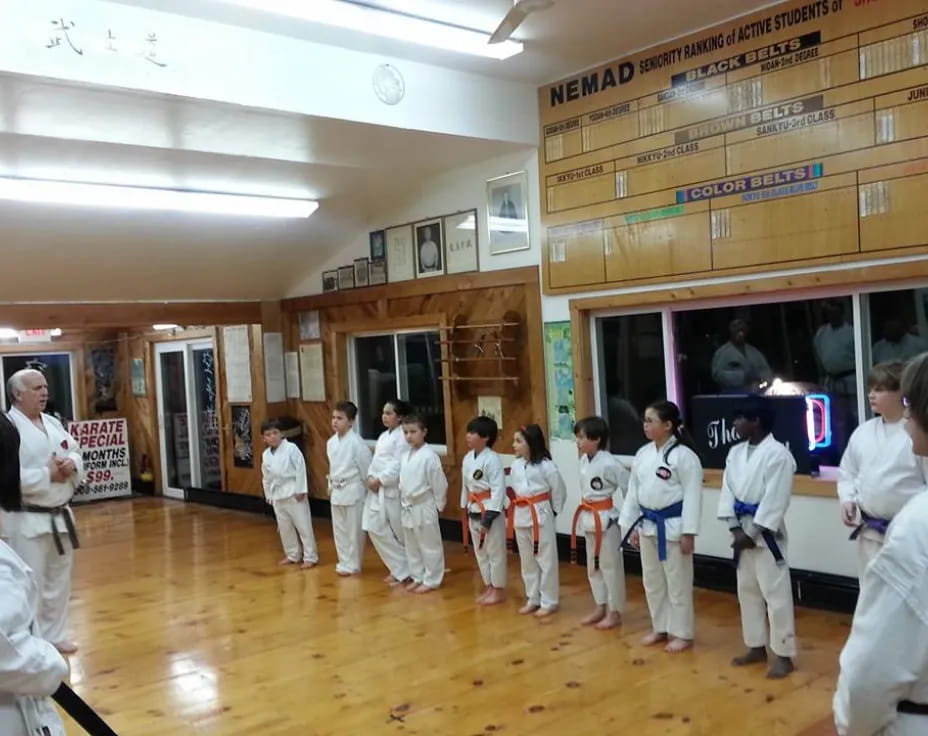 a group of people in white karate uniforms in a room