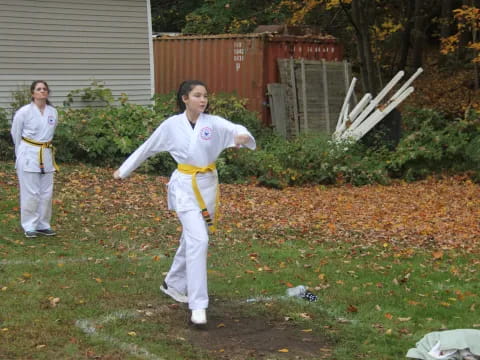 a group of people in white karate uniforms outside