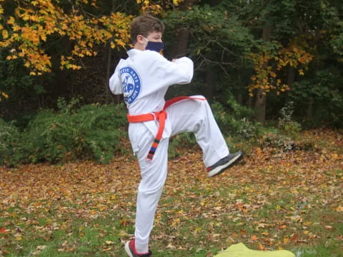 a man in a karate uniform jumping in the air