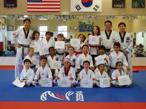 a group of people in white karate uniforms posing for a photo