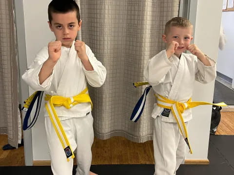 a couple of boys in karate uniforms