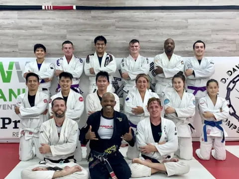 a group of men in white karate uniforms posing for a photo