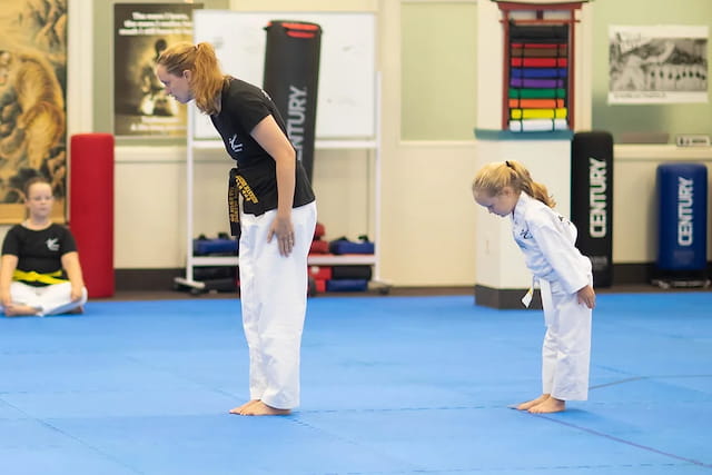 a person and a child in a karate class