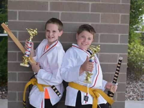 two boys in traditional japanese garb holding swords